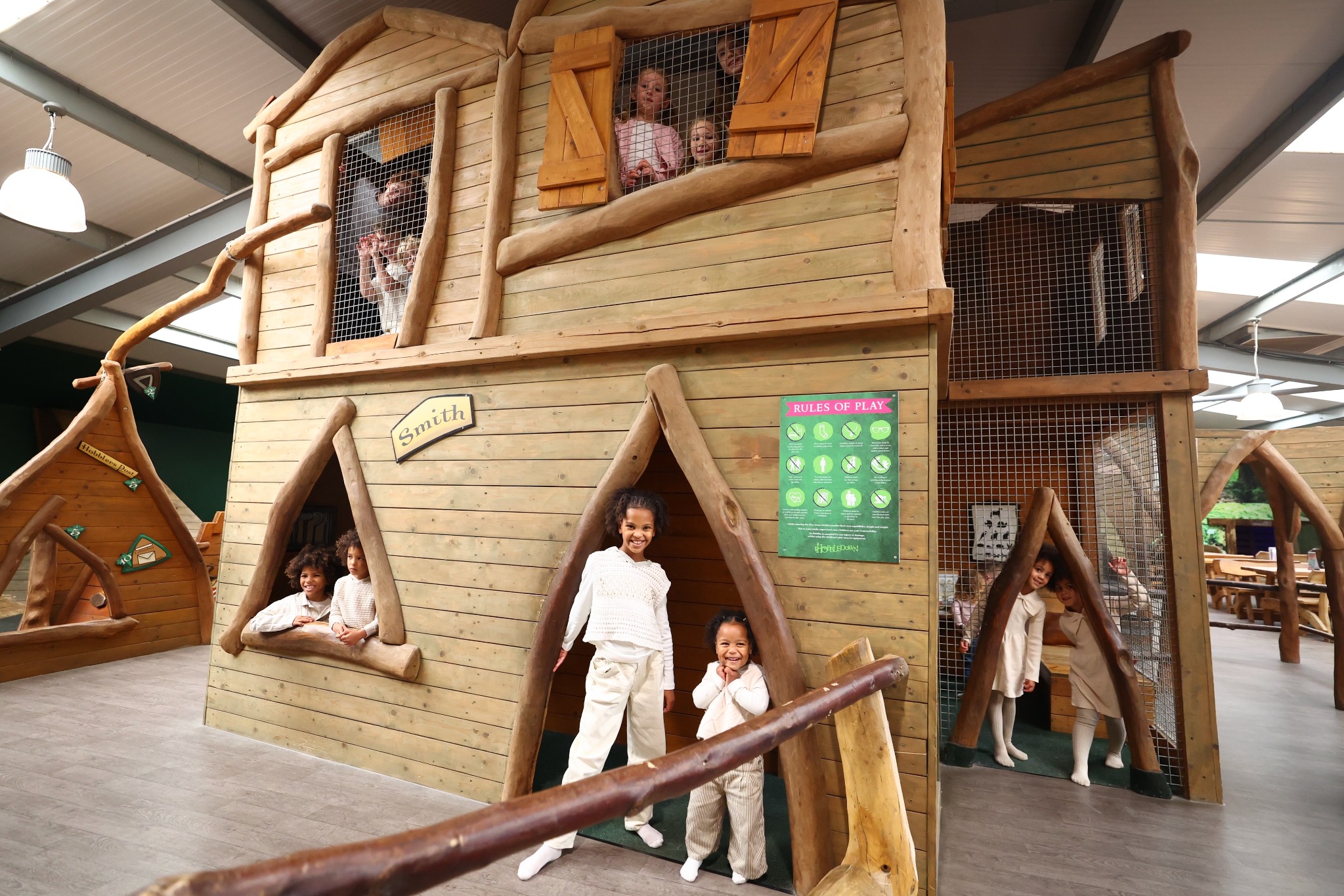 Children playing inside a wooden indoor play barn at Hobbledown Epsom adventure park