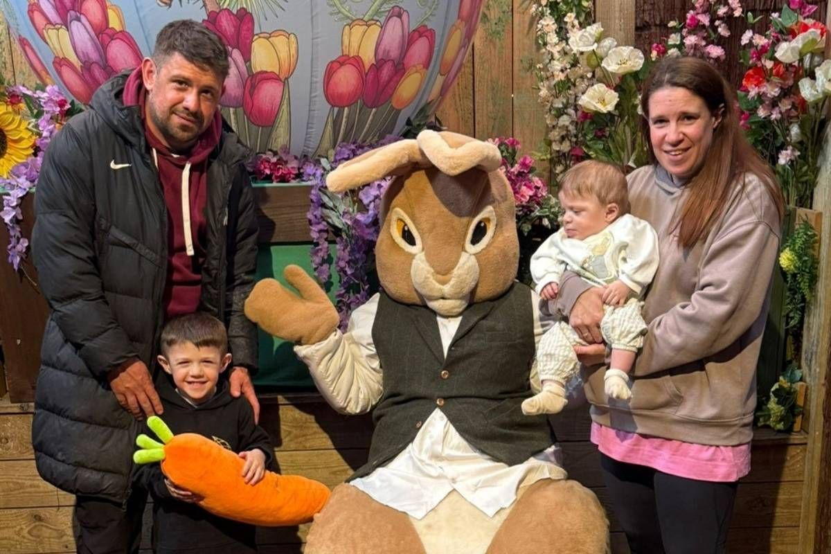Parents and young children standing beside Easter Bunny mascot at Hobbledown, Epsom