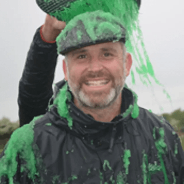 Richard Farley, founder of Hobbledown, smiling while covered in green slime during a fun challenge