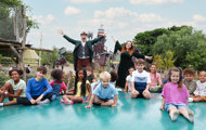 Children and Hobbledown Heath characters posing on the jumping pillow at the outdoor adventure park, Hounslow, West London