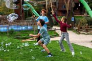 Children playing with wooden swords and bubbles at Hobbledown Epsom adventure park