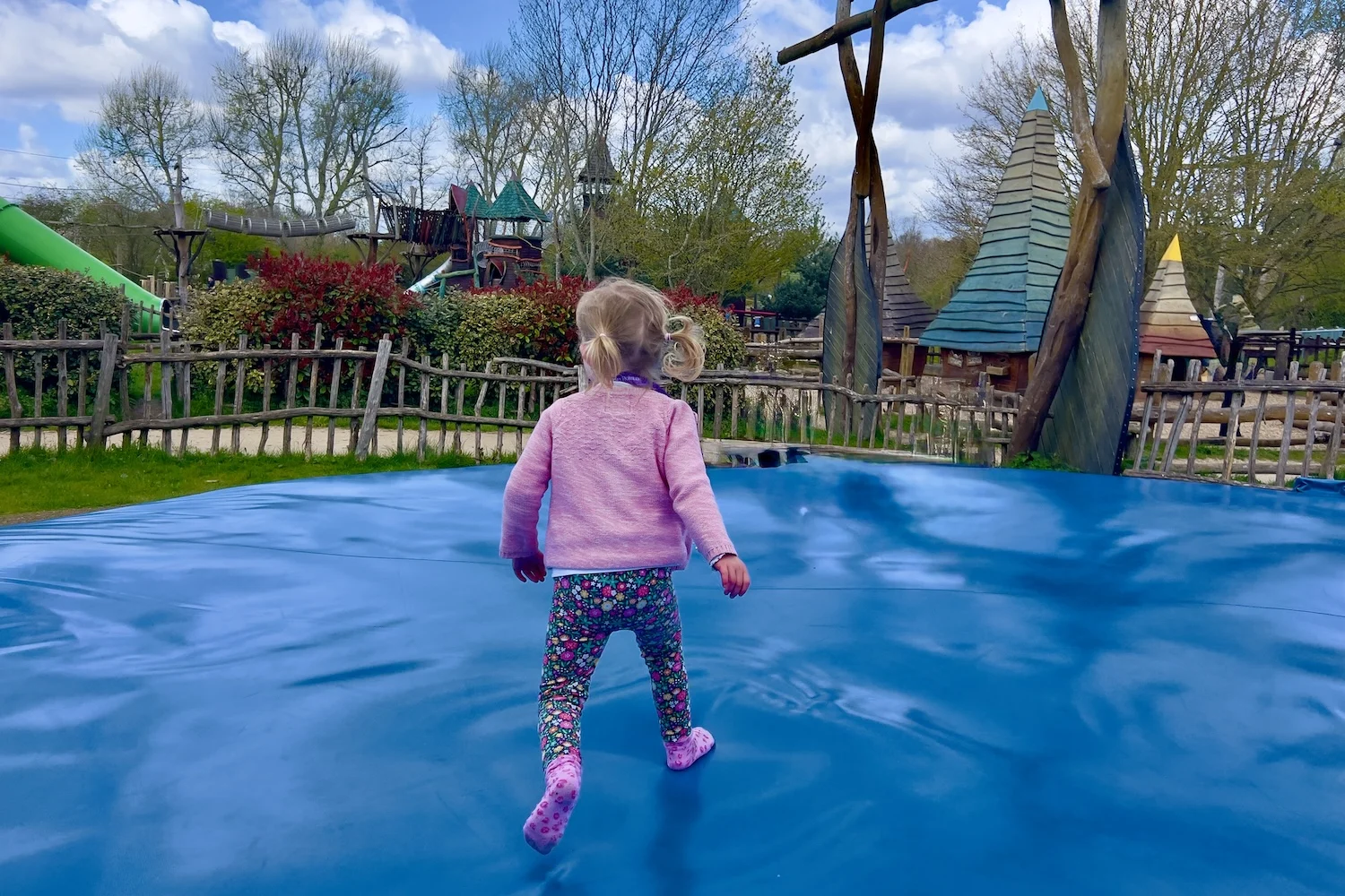 Child playing on a giant jumping pillow at Hobbledown Epsom adventure playground in Surrey during a family day out.