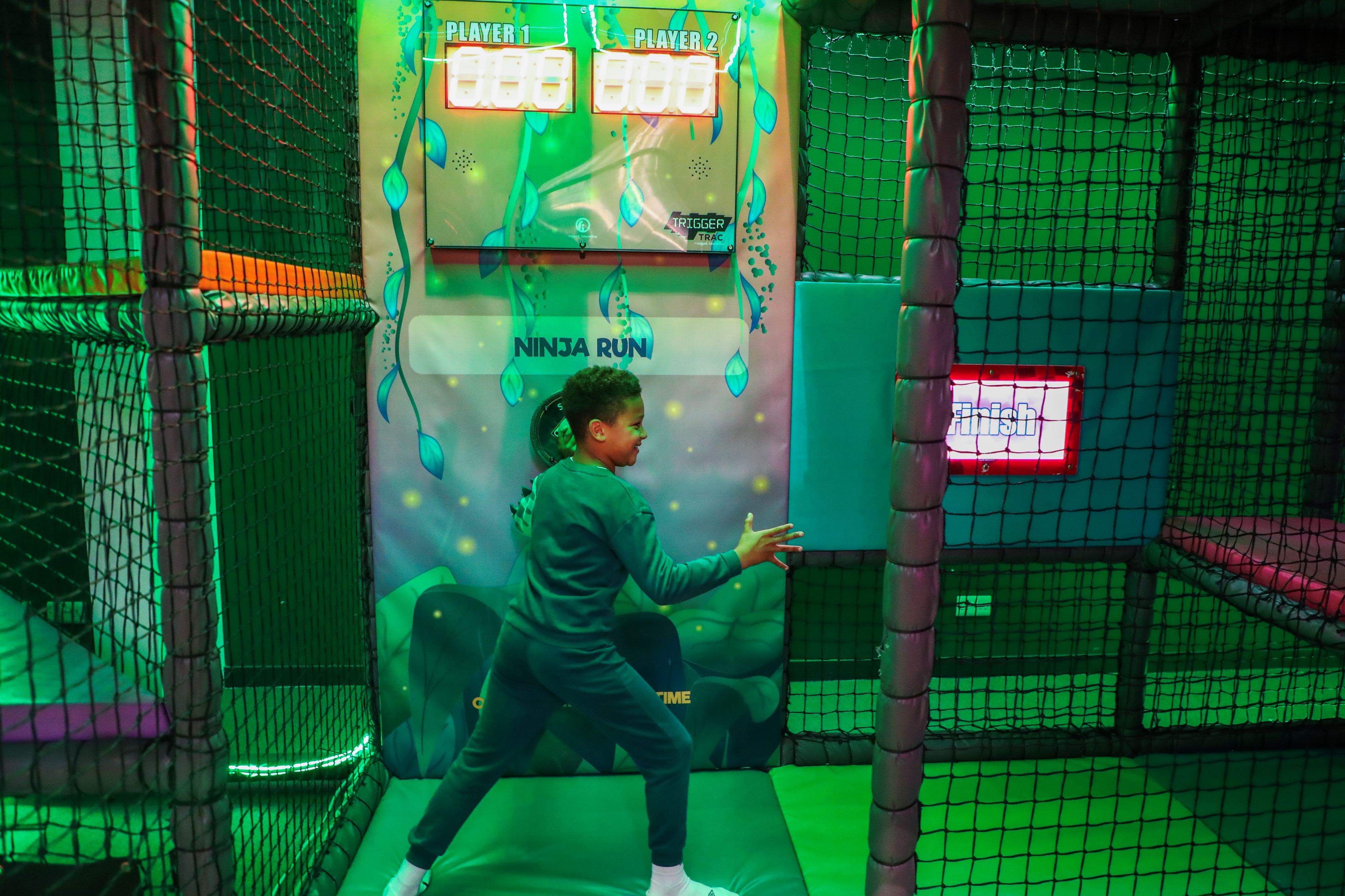 Child completing ninja run obstacle at indoor play area in Hounslow
