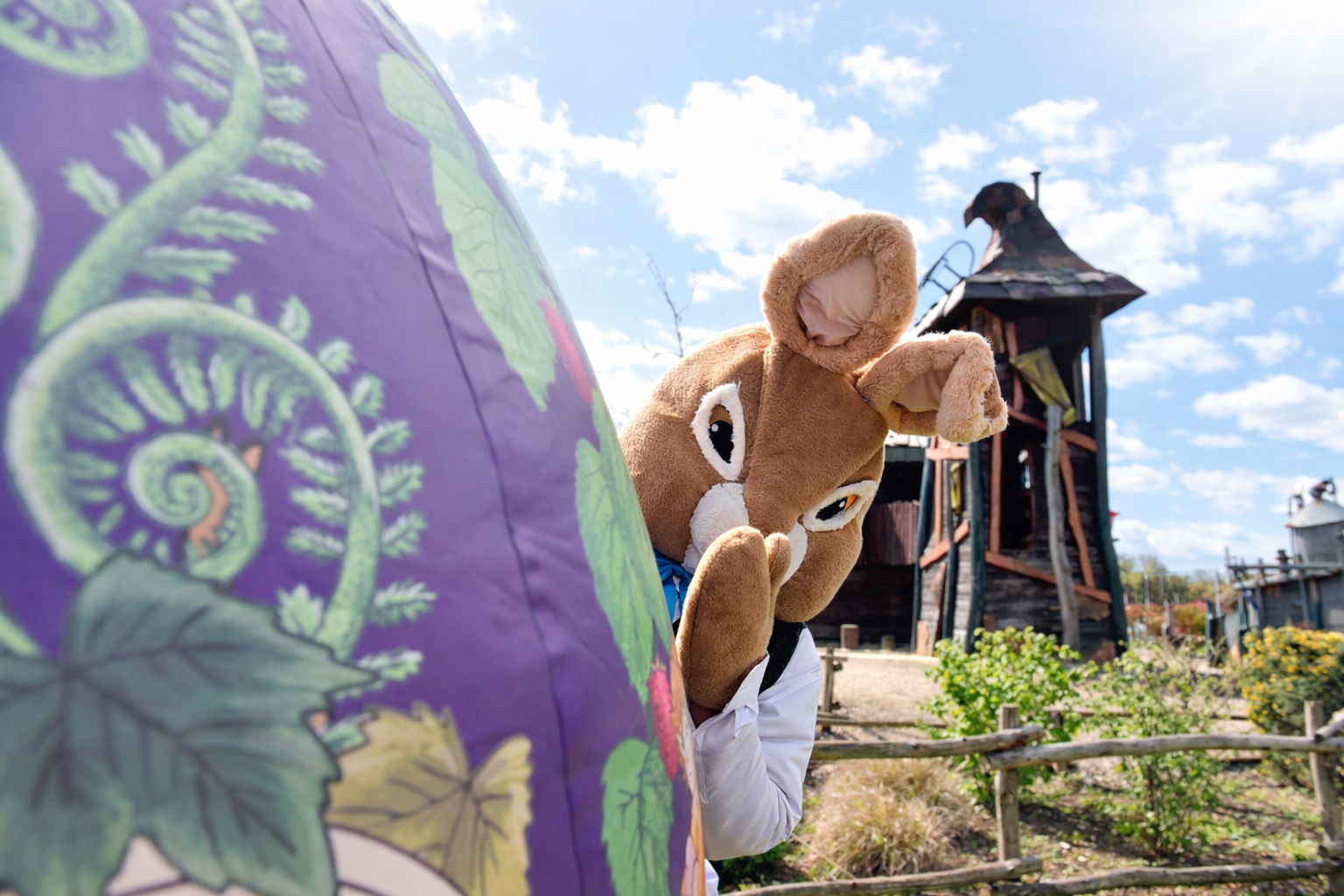 Easter Bunny peeking from behind giant egg at Hobbledown Heath Easter trail experience