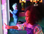 Children enjoying interactive sensory light display at Hobbledown Heath indoor play centre, West London
