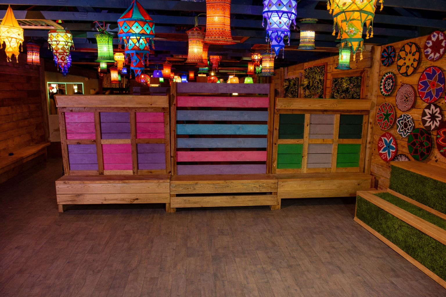 Indoor community space hire at Hobbledown Epsom with colourful lantern lighting, wooden seating and open area for local groups, classes and meetups.